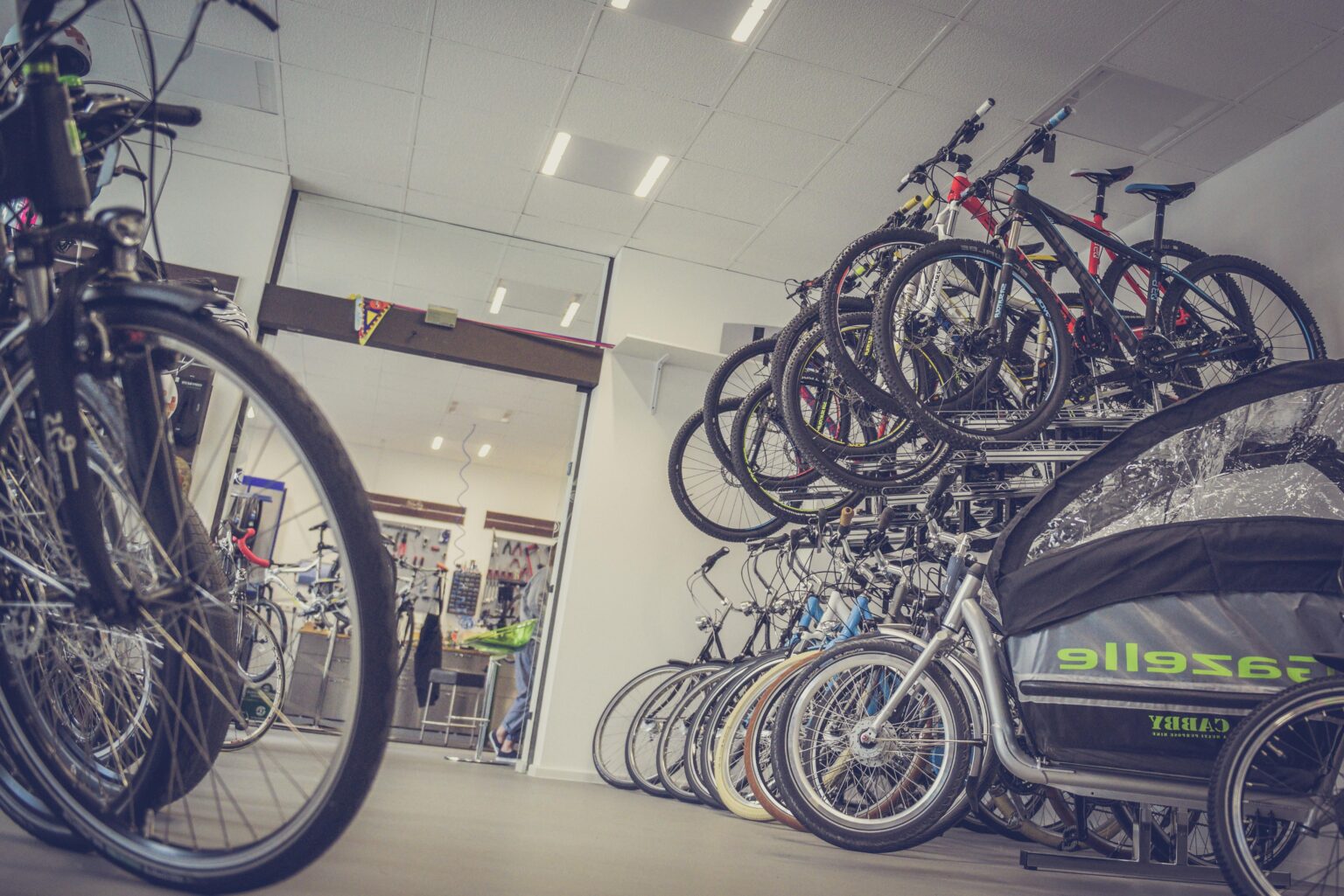 Der Hinterraum eines Fahrradladens oder einer Fahrradwerkstatt. Fahrräder hängen von der Decke und stehen an den Wänden auf dem Boden.